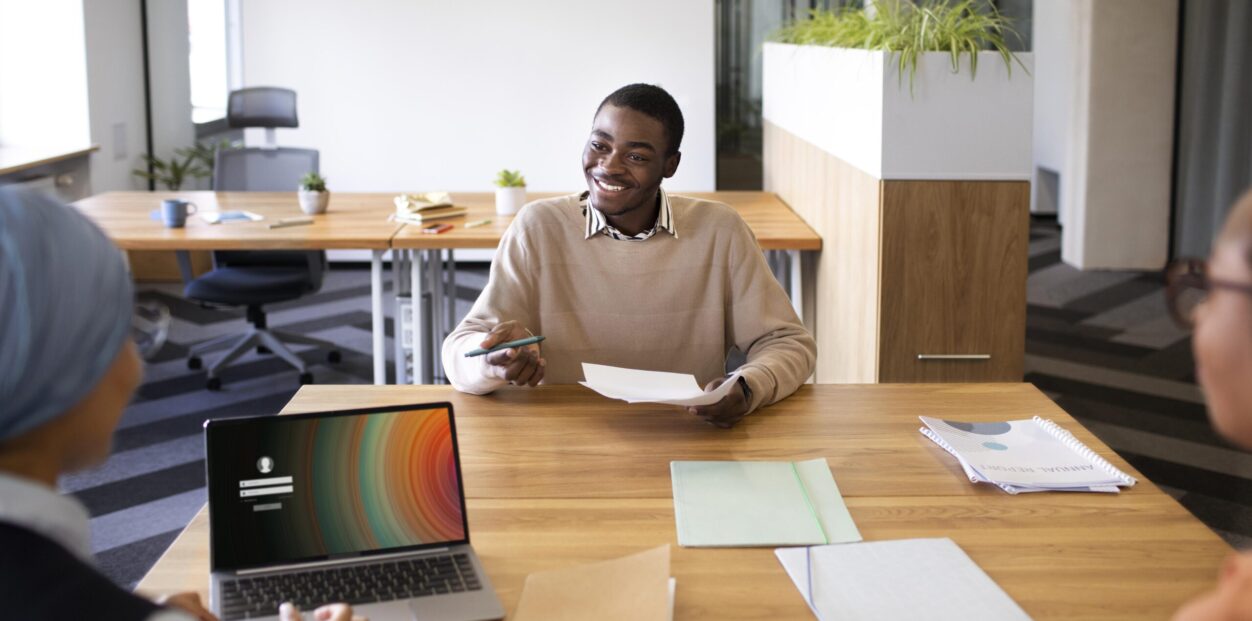 man-sitting-down-office-job-interview-desk-with-his-employers